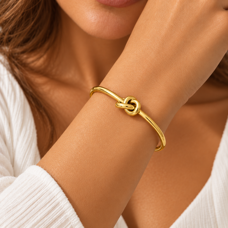 Gold stainless steel knot bracelet worn on wrist